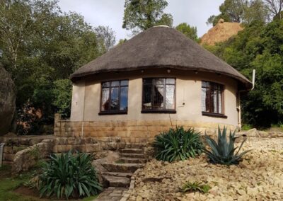 Charming Round Thatched Cottage with Stone Pathway and Garden