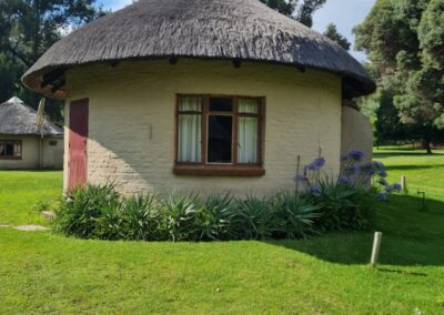 Charming Round Thatched Cottage with Stone Pathway and Garden